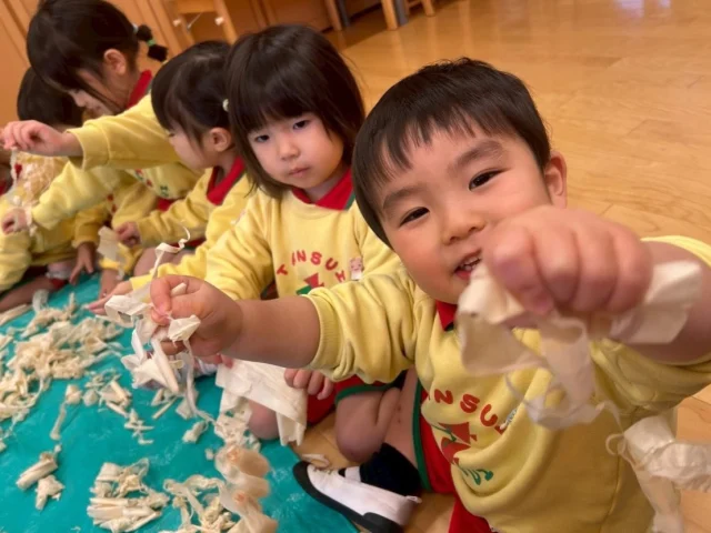 【もぐもぐDAY】
　木育を取り入れてかんなくずで感触遊びをしました➰🤲木との触れ合いで香りや手触り、感触を楽しみ、五感を養います🪵「いい匂い！」「お家の匂いみたい！」と、みんな木の癒される匂いと共に楽しんでいましたよ🍀かんなくずをちぎってみたり、頭の上から落としてシャワーのようにして遊んでました🌟

#福岡市保育園
#保育園
#幼稚園
#木育
#かんなくず遊び